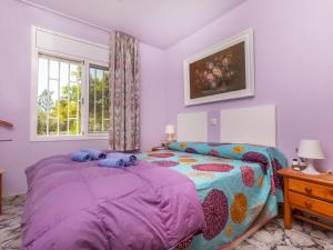 a bedroom with a purple bed and a window at Villa Sueño I by Interhome in L'Ametlla de Mar +22 photos