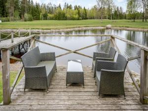 a group of chairs sitting on a wooden bridge over a pond at Holiday Home Lövåsen by Interhome in Bottnaryd