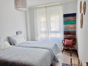 a bedroom with two beds and a window at VerdeAgua Cantabria con Piscina in Ajo
