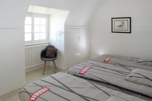 PlouarzelにあるTy Kerescarのベッドと椅子と窓のある寝室