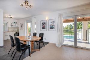 a dining room with a wooden table and black chairs at Villa Antonia, a beautiful pool villa in a large 1900 sqm garden in Modrušani