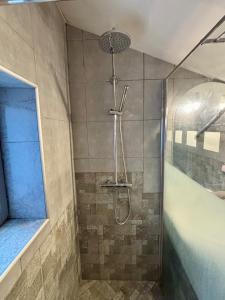 a shower with a shower head in a bathroom at Maison à la campagne Les quatre vents in Saint-Martin-dʼAbbat