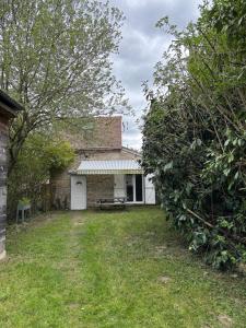 a brick house with a picnic table in the yard at Maison à la campagne Les quatre vents in Saint-Martin-dʼAbbat