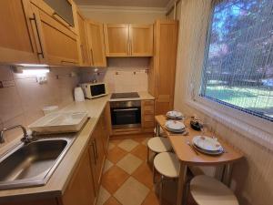 a small kitchen with a sink and a table at Jókai Apartman Szarvas in Szarvas