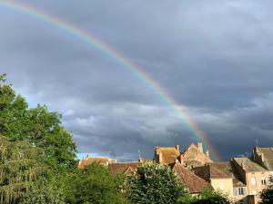 a rainbow in the sky over a city at La Garçonnière appartement climatisé in Charolles