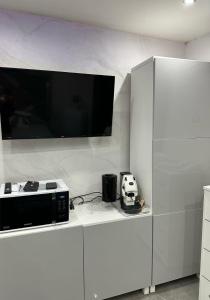 een keuken met een magnetron en een tv op een aanrecht bij Patty House in Napels