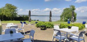 a group of tables and chairs with a view of the water at Noce i Dnie in Pierkunowo