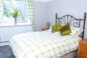 a bedroom with a bed with green pillows and a window at 3 bedroom house in Walsden