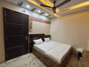 a bedroom with a bed and a ceiling fan at SEVEN SEVEN HOMESTAy in Amritsar