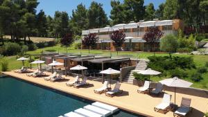 ein Resort mit einem Swimmingpool mit Stühlen und Sonnenschirmen in der Unterkunft Sani More & Sani Woods in Sani Beach + 19 Fotos