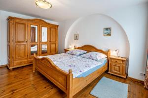 a bedroom with a wooden bed and a wooden cabinet at Ferienwohnung Kolibri in Naumburg