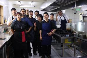 a group of chefs posing for a picture in a kitchen at Pampa Lodge, Quincho & Caballos in Torres del Paine