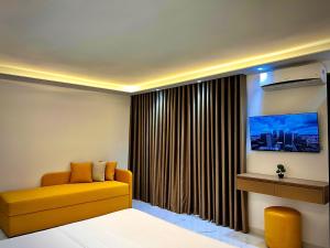 a living room with a yellow couch in front of a window at Dine Hotel in Ksamil