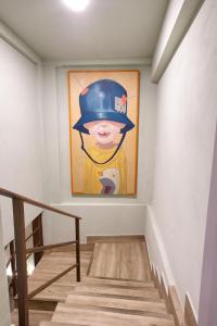 ein Gemälde eines Jungen mit Hut an einer Wand in der Unterkunft Cuencaloft la Orquídea de la Plaza in Cuenca
