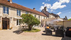 a courtyard with a tree in front of a building at Villa des Lilas - Champagne & SPA in Buxeuil