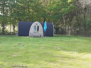 a small tent in a yard with a umbrella at Camping Onlycamp Port Sainte Marie in Malicorne-sur-Sarthe