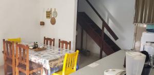 a dining room with a table and yellow chairs at Sítio Chã do Cajá in Sao Benedito do Sul