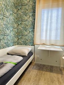 a small bedroom with a bed and a window at Neuwertiges Apartment mit schnellem WLAN, Glasfaser, R7 in Freiberg am Neckar