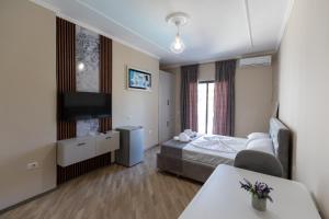 a hotel room with a bed and a flat screen tv at Hotel Apart Resilient in Golem