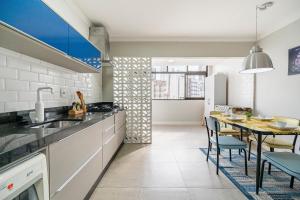 a kitchen with a table and a dining room at Ruth de Sá 3 Dorm Quadra Mar by Achei Camboriú in Balneário Camboriú