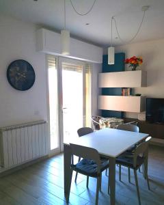a living room with a dining room table and chairs at Appartamento Passeggiata Vista Mare in Viareggio +2 photos