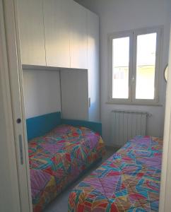a bedroom with two beds and two windows at Appartamento Passeggiata Vista Mare in Viareggio