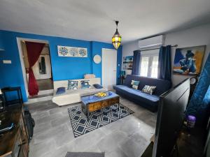 a living room with blue walls and a blue couch at Le petit paradis de Nicole in Villanueva de Algaidas +19 photos