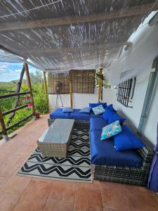 a porch with blue couches and a table at Le petit paradis de Nicole in Villanueva de Algaidas