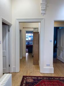 a hallway with two doors and a room with a rug at Artists Seaside Sanctuary in St. Leonards