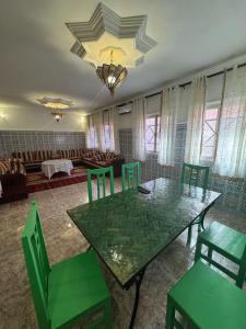 comedor con mesa verde y sillas en 5 min Aéroport Appartement avec Terrasse et Grand Appartement, en Marrakech