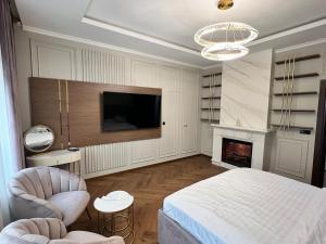 ファガラシュにあるHorace Exclusive Residence Fagarasのベッドルーム(ベッド1台、テレビ、暖炉付) +33枚の写真