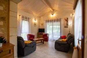 a living room with two couches and a table at Moulin neuf de combecave in Saint-Amand-de-Vergt