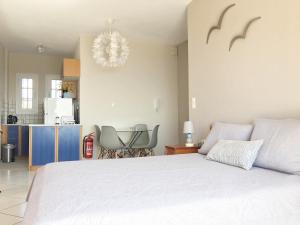 a bedroom with a white bed and a kitchen at Arillas view 1 in Kefalári
