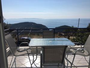 a table and chairs on a balcony with the ocean at Arillas view 1 in Kefalári