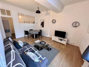 a living room with a blue couch and a table at La Halte, Proche-gare, cosy, Spacieux in Issoudun +4 photos