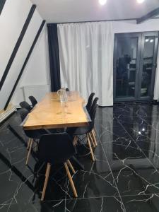 a dining room with a wooden table and black chairs at A frame Ina și Cristi in Tîrsa
