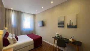 a hotel room with a bed and a desk at MyTrip Porto in Matosinhos