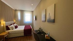 a hotel room with a bed and a desk with a bed sidx sidx sidx sidx at MyTrip Porto in Matosinhos