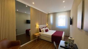 a hotel room with a bed and a chair at MyTrip Porto in Matosinhos