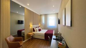 a hotel room with a bed and a desk at MyTrip Porto in Matosinhos