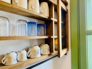 a row of blue and white cups on a shelf at Sophia's Apartments - Lipsi Rosemary in Lipsoi