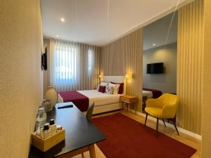 a hotel room with a bed and a table and chair at MyTrip Porto in Matosinhos