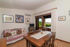 Punta MolaraVilla Molara的客厅里有一张桌子和一张沙发