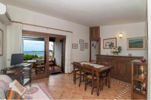 Punta MolaraVilla Molara的带桌子的客厅和餐厅