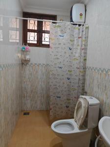 ein Badezimmer mit Toilette und Duschvorhang in der Unterkunft the 3BHK beach villa near colva beach in Colva + 13 Fotos