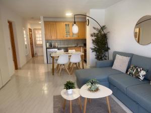 アロナにあるApartment Jasmine Los Cristianos, heated poolの青いソファとテーブルのあるリビングルーム
