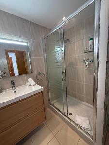 アロナにあるApartment Jasmine Los Cristianos, heated poolのガラスのシャワーと洗面台を備えたバスルーム