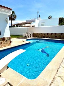 a swimming pool in front of a house at Chalet con piscina privada cerca del mar in Cala'n Bosch