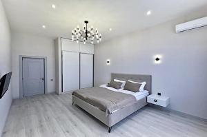 a bedroom with a bed and a chandelier at Qafqaz Modern Harmony in Gabala +24 photos