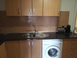 a kitchen with a sink and a washing machine at Casa Mila in Puerto del Rosario +20 photos